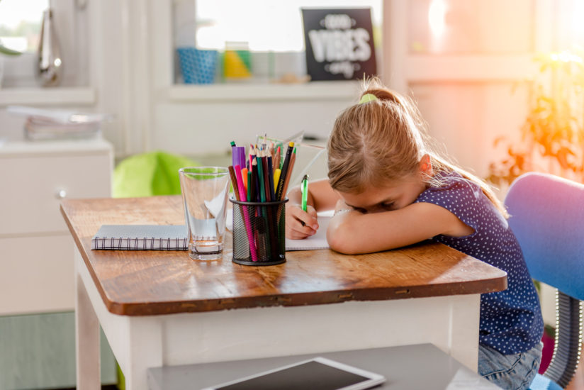 Girl in blue shirt having problem with concentration to finish home work